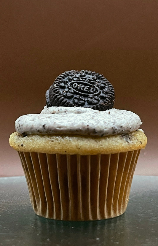 Cupcake with Oreo frosting and cookie on a brown background